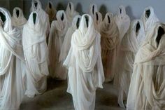 several white dresses are lined up in rows and one is draped over the other side