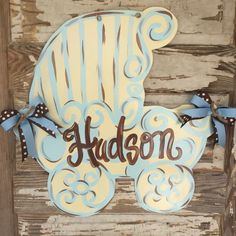 a wooden sign that says hudson with a blue and white striped teddy bear on it