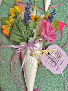 a vase filled with flowers on top of a green table next to a heart shaped tag