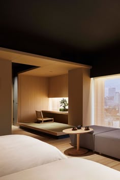 a hotel room with two beds, a couch and a table in front of a window