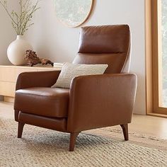 a living room with a brown leather chair in the middle and a round mirror on the wall