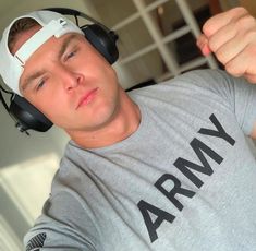 a man with headphones on his ears wearing a t - shirt that says army