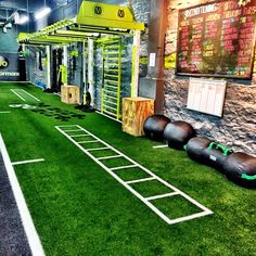 an indoor gym with artificial turf and equipment