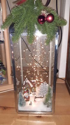 a glass box with christmas decorations and lights inside