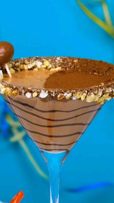 there is a chocolate martini with nuts on the rim and garnished with candy