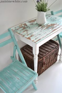 an old table and chair with a basket underneath it