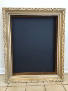 a gold frame sitting on top of a tiled floor