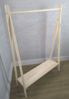 a wooden bed frame sitting on top of a hard wood floor next to a wall