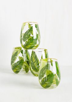 four glasses with green leaves painted on them