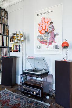 a record player sitting on top of a table in front of a book shelf filled with books