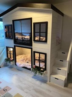 there is a doll house with two floors and windows on the second floor that has stairs leading up to it