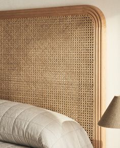 a headboard made out of wicker with a lamp next to it