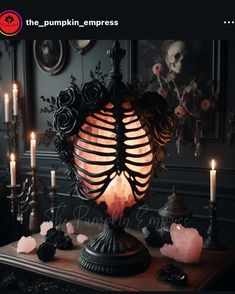 a table topped with lots of candles next to a skeleton lamp and some skulls on it