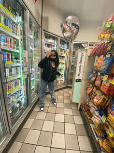 a woman is taking a selfie in front of refrigerators at a grocery store