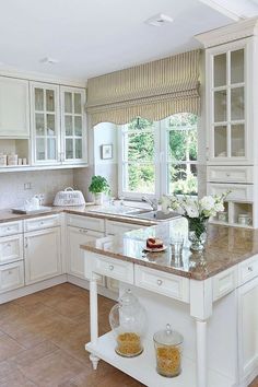 a large kitchen with white cabinets and marble counter tops, along with a center island