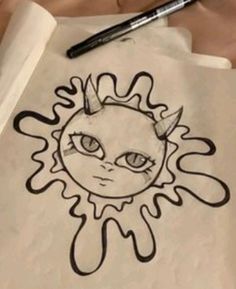 a paper with a drawing of a sun on it and a pen next to it