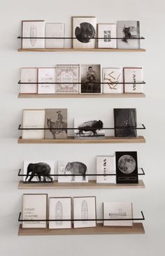 three wooden shelves with books and pictures on them