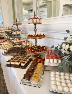 an assortment of desserts and pastries on a long table in a banquet hall