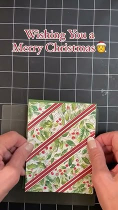 two hands are holding up a christmas card