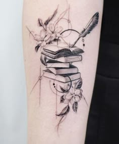 a tattoo with books and flowers on it