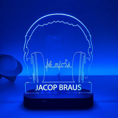 a neon sign with headphones on it that says jacop braus in front of a blue background