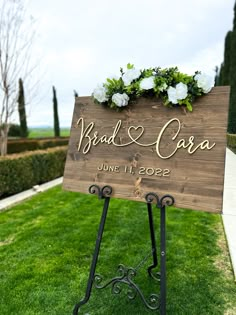 a wooden sign sitting on top of a lush green field