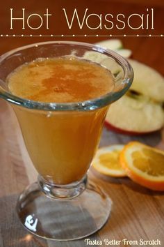 an apple cider is sitting on a table next to sliced oranges