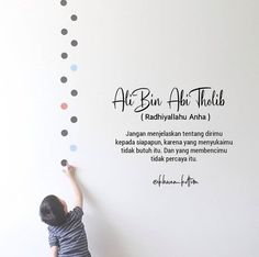 a little boy painting on the wall with polka dot decals in black and white