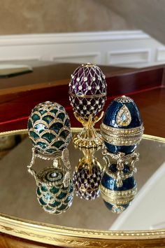 an assortment of faber's jeweled eggs on a mirrored surface in front of a mirror