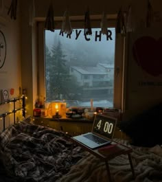 a bed room with a laptop computer on it's desk next to a window