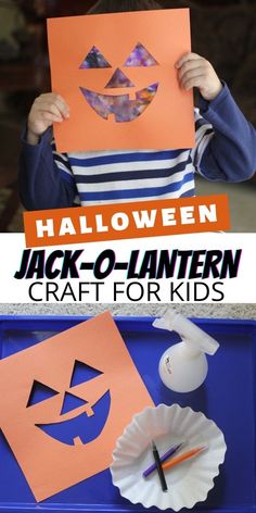 a young boy holding up a paper jack o lantern craft for kids