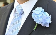 a man in a suit and tie with a boutonniere on his lapel