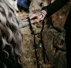 two people holding hands with chains attached to them and one person wearing a black dress