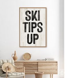 a living room with a chair, table and poster on the wall that says ski tips up