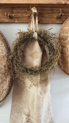 an old bag with a wreath hanging from it's side next to two wicker baskets