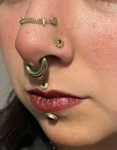 a woman with gold piercings on her nose