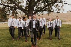 a group of men in suits and ties standing next to each other near a tree