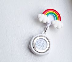 a white clock with a rainbow on it