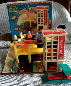 an action garage playset in its box on a chair with it's contents