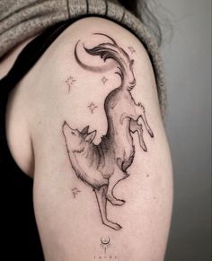 a woman with a tattoo on her shoulder has a fox and stars in the sky