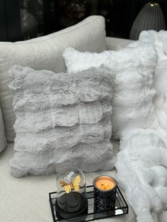 a white couch with pillows and candles on it