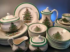 a table topped with lots of white and green christmas themed dinnerware next to each other