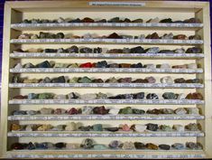 a wooden shelf filled with lots of different types of rocks on it's sides