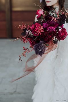 a woman holding a bouquet of flowers in her hands