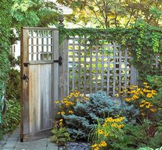 a wooden gate surrounded by plants and flowers