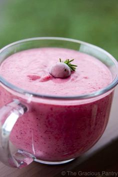 a pink smoothie in a glass with a strawberry on top