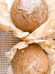 two loaves of bread sitting on top of a cooling rack next to each other