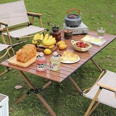 a picnic table with food and drinks on it in the middle of a grassy area