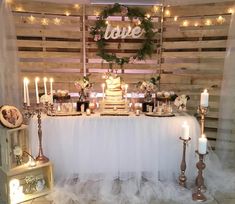 a table topped with lots of cake and candles next to a wooden sign that says love