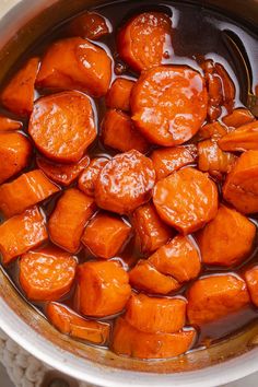 cooked carrots are in a pot with brown liquid on the top and bottom, ready to be eaten